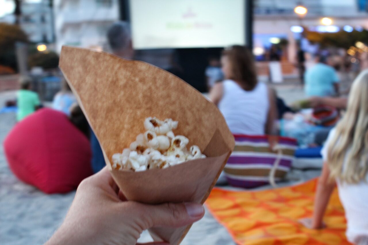 Hand holding popcorn at an outdoors cinema