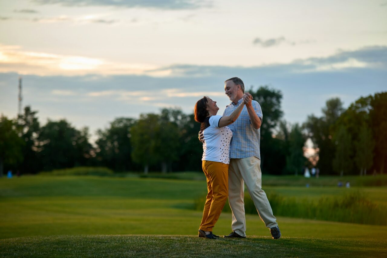 Happy couple dancing outdoors.
