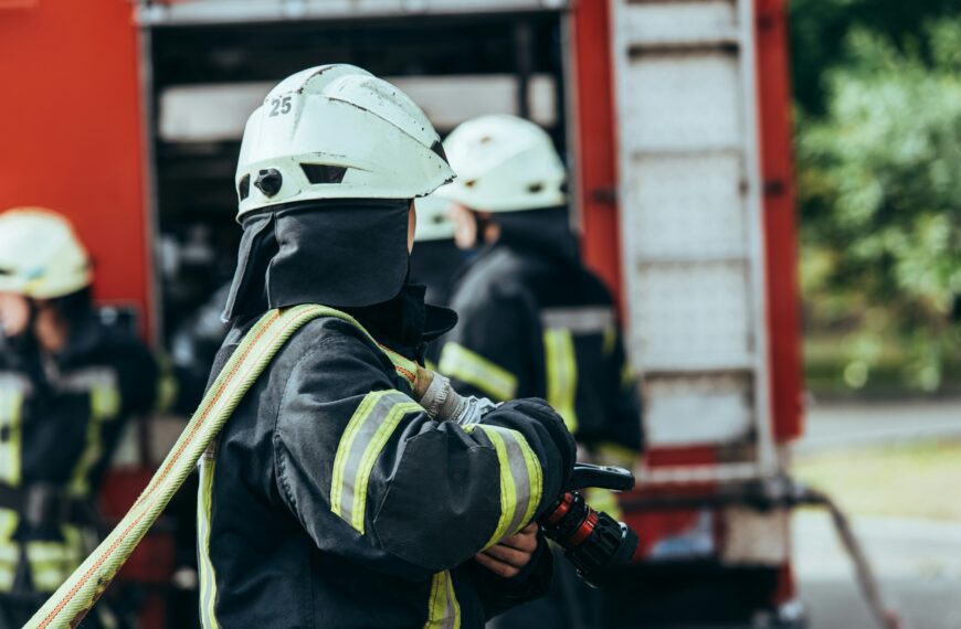 partial view of firefighters brigade and fire truck on street