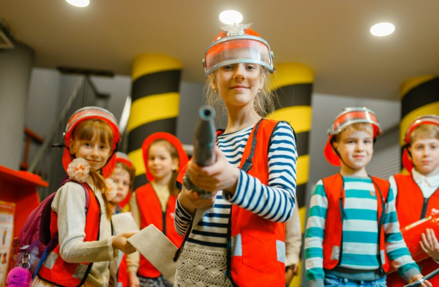 Child with hose in hands playing firefighter