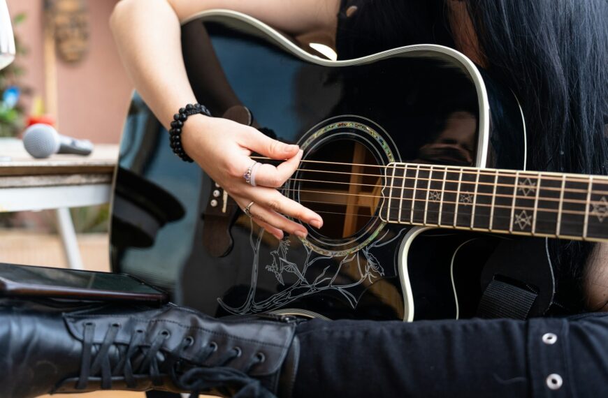 Rock guitarist woman playing with an acoustic guitar