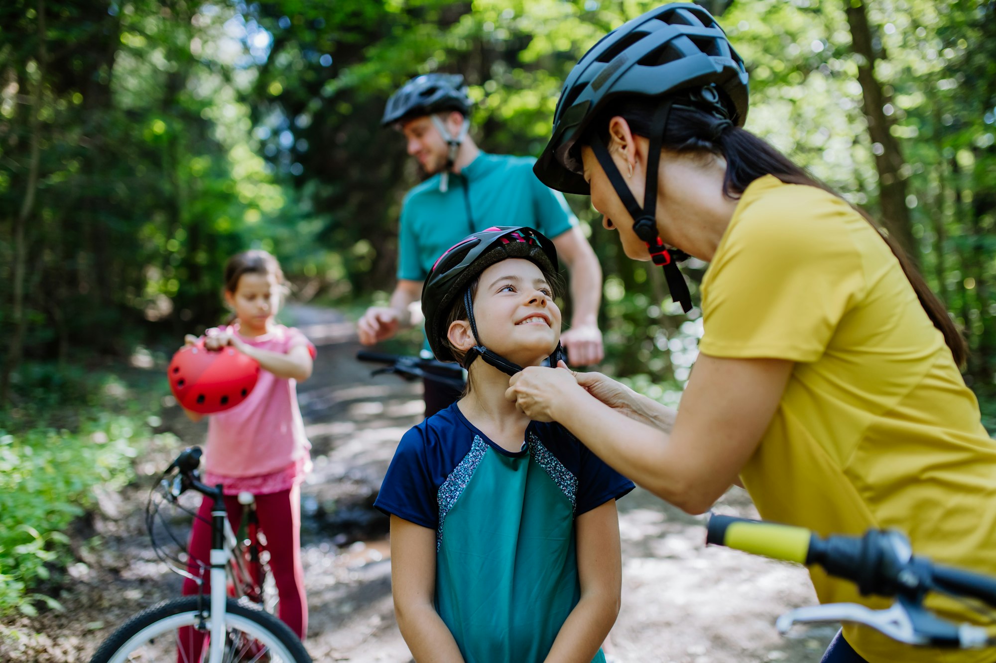 Young family with little children at bike trip together in nature.