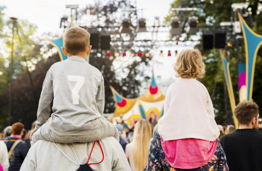Boy and girl being carried on shoulders during festival