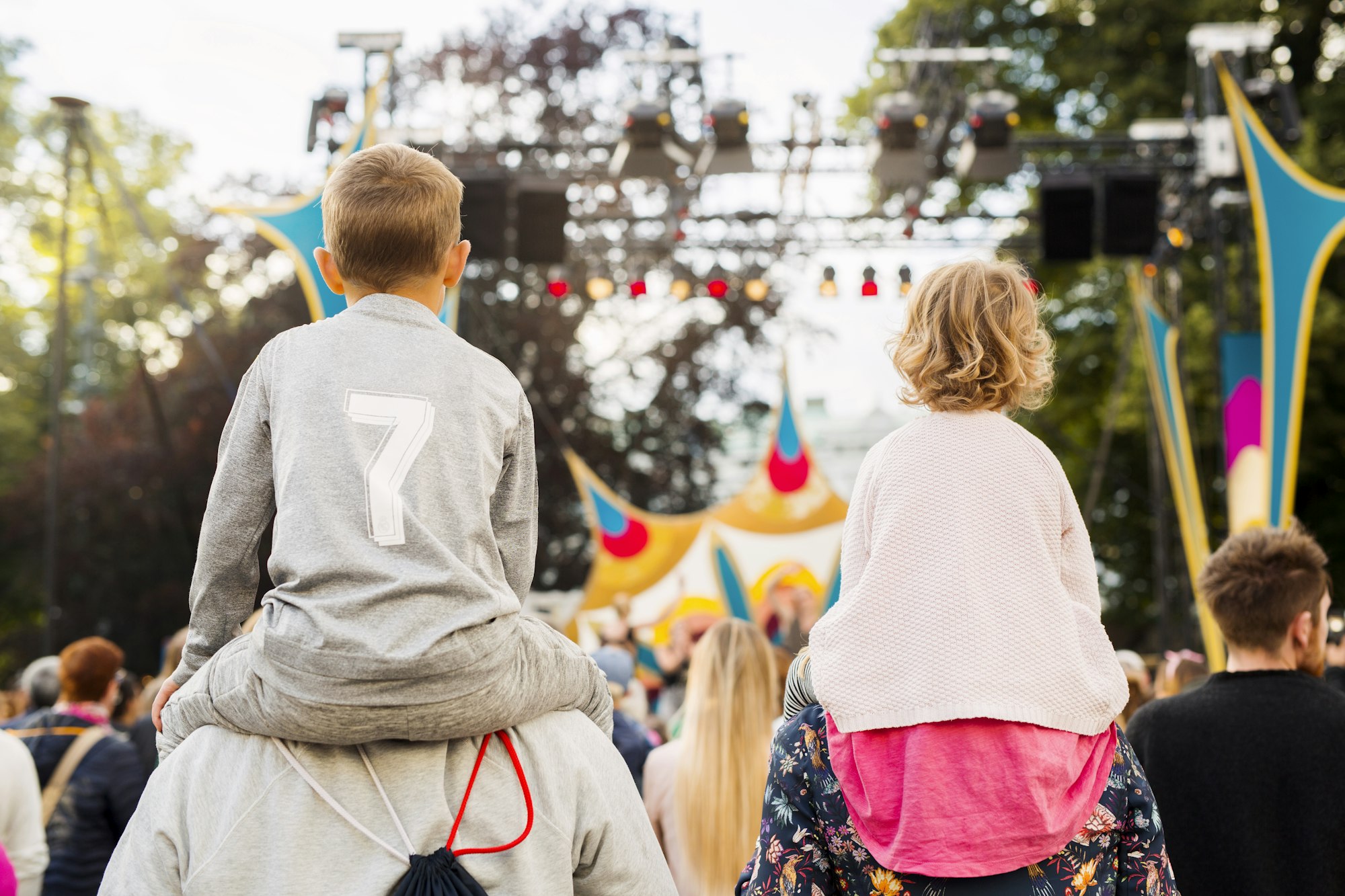Boy and girl being carried on shoulders during festival
