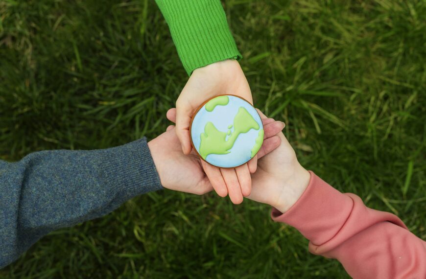 Earth Day concept. Hands hold gingerbread in the shape of the Earth. Care for the environment.