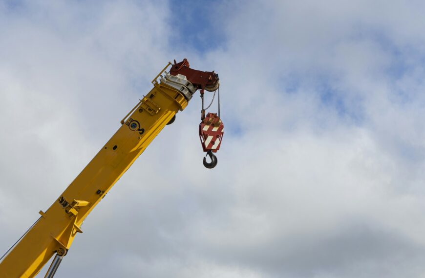 Low angle shot of a construction crane against the cloudy sky