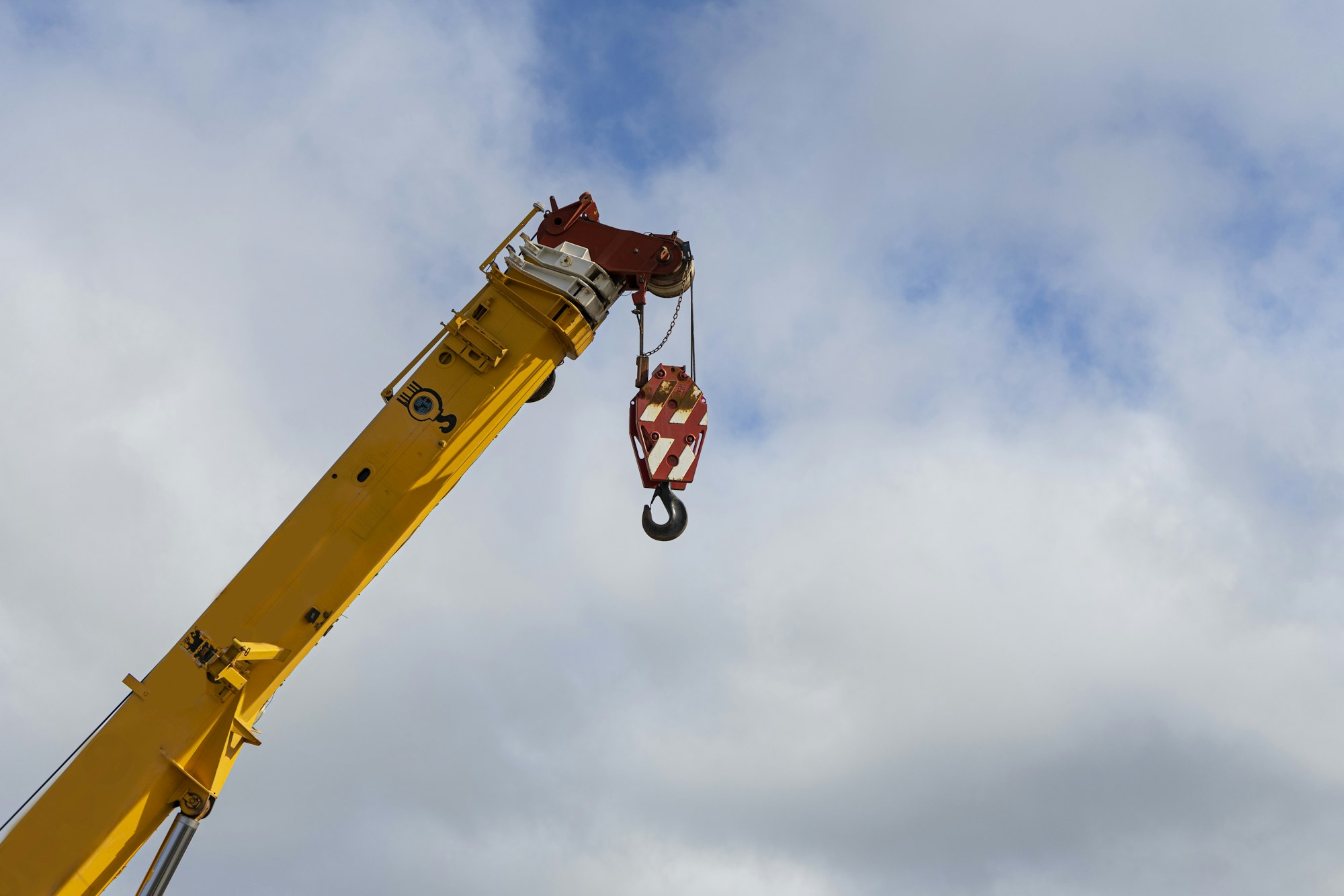 Low angle shot of a construction crane against the cloudy sky