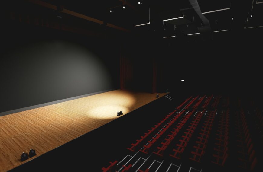Theatre with empty stage in spotlight. Red theater curtain and seats
