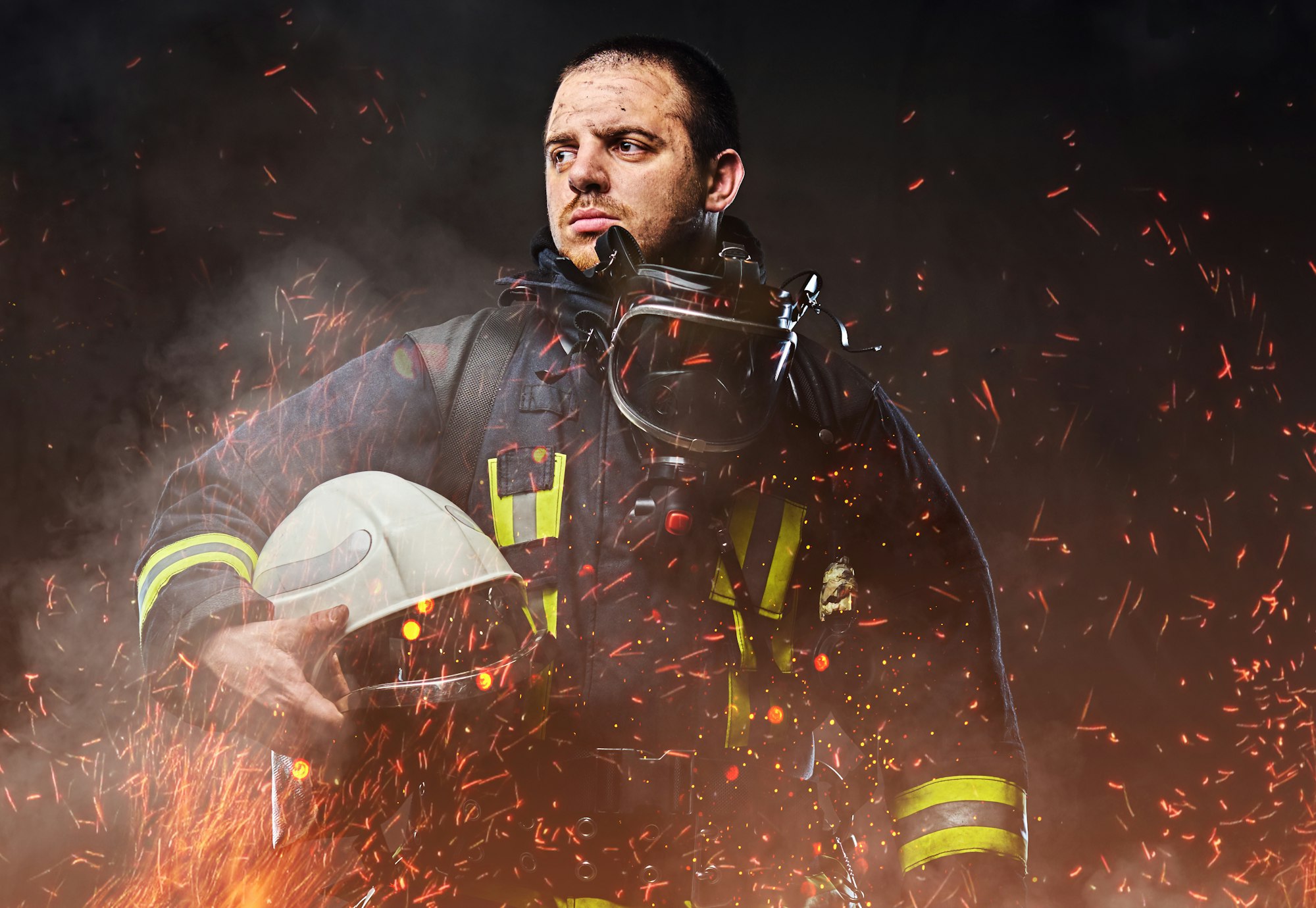 A firefighter dressed in a uniform in a studio.