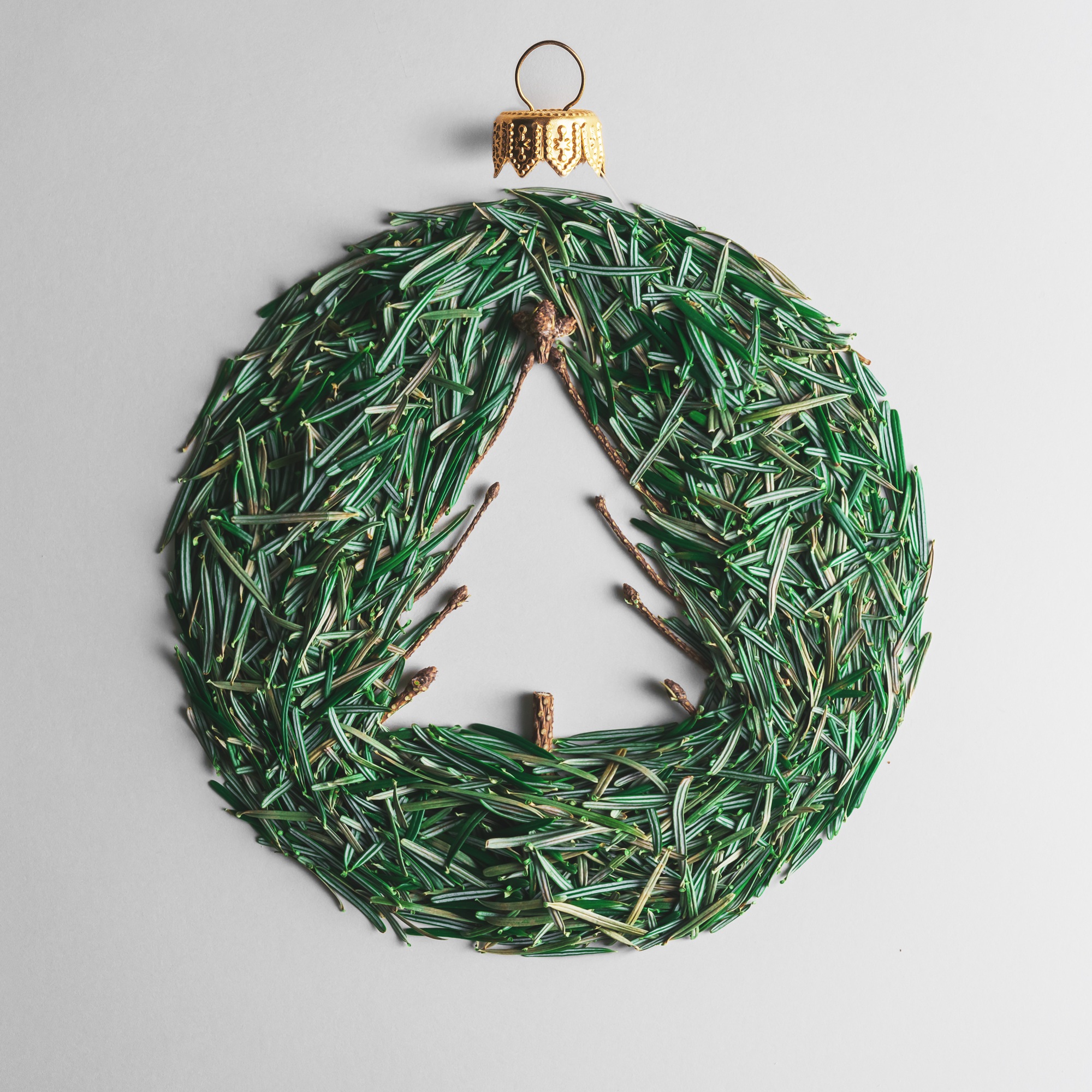 Christmas ball of Christmas tree needles on a gray background. Creative Christmas composition.