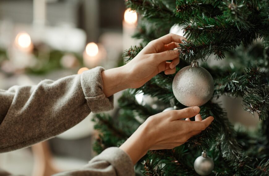 Female Hands Hanging Ornament on Christmas Tree