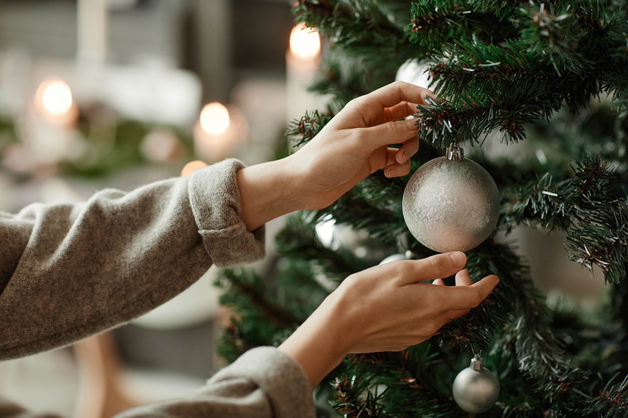 Female Hands Hanging Ornament on Christmas Tree