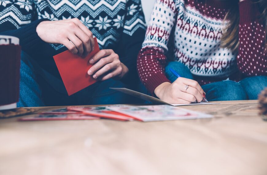 Merry family writing Christmas postcards