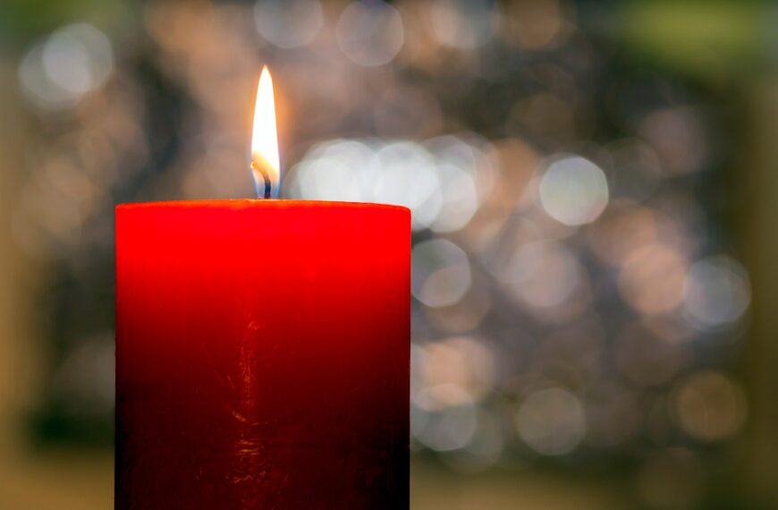 Candles light. Christmas candle burning at night. Abstract candle background. Golden light of candle