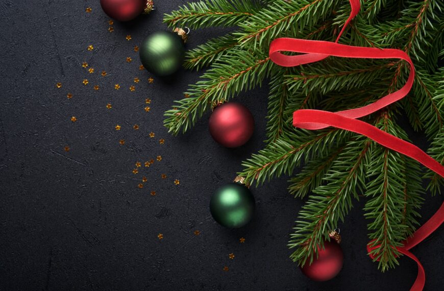 Christmas Decoration. Holiday Decorations with baubles, fir branches and present on dark black backg