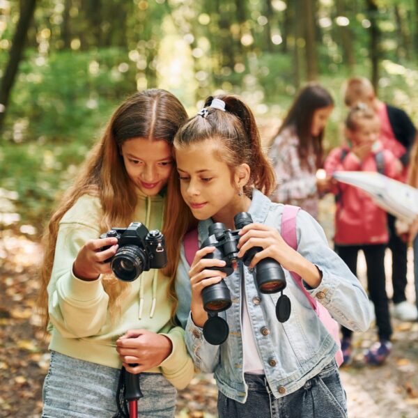 Conception of tourism. Kids in green forest at summer daytime together