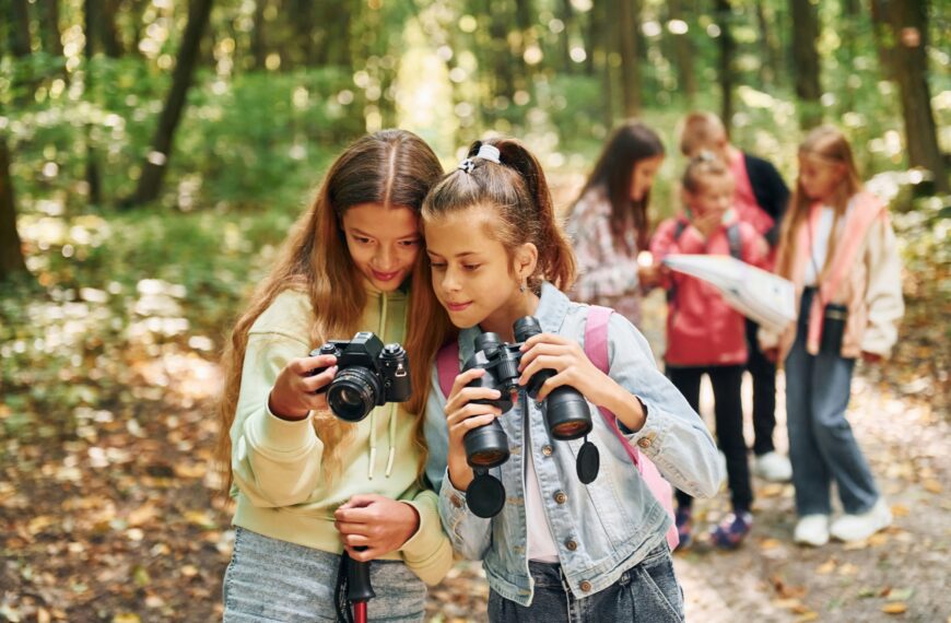 Conception of tourism. Kids in green forest at summer daytime together