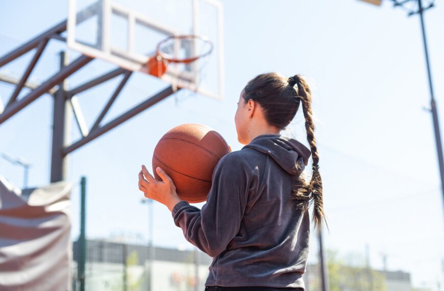 Girl with a basketball on the background of the city. Street basketball.