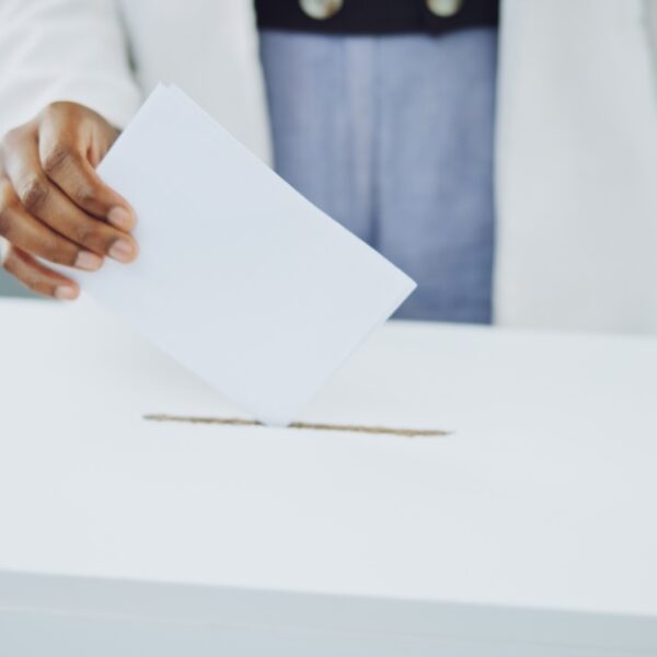 Hand, ballot and box for vote paper at president election cast, poll station choice or government s