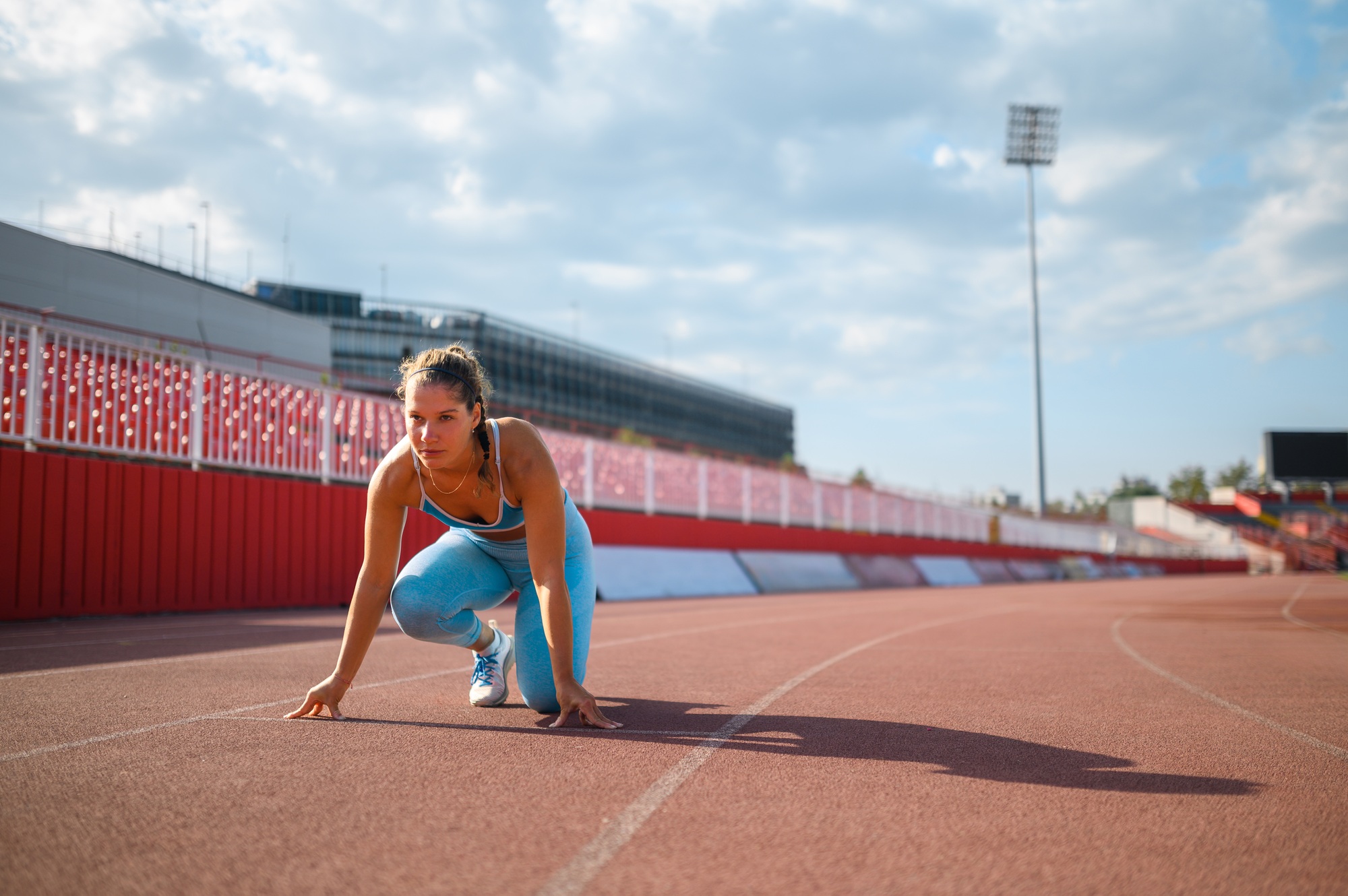 Portrait of a young female racer preparing for a race in a sports arena
