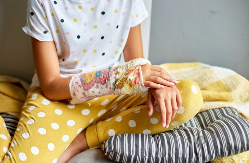 Teen girl with a broken arm at home an orthopedic cast