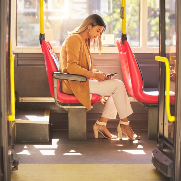 Woman in bus, sitting and typing on smartphone for social media, email and and travel on urban comm