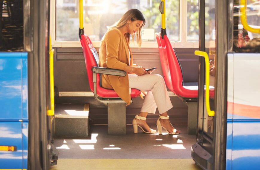 Woman in bus, sitting and typing on smartphone for social media, email and and travel on urban comm