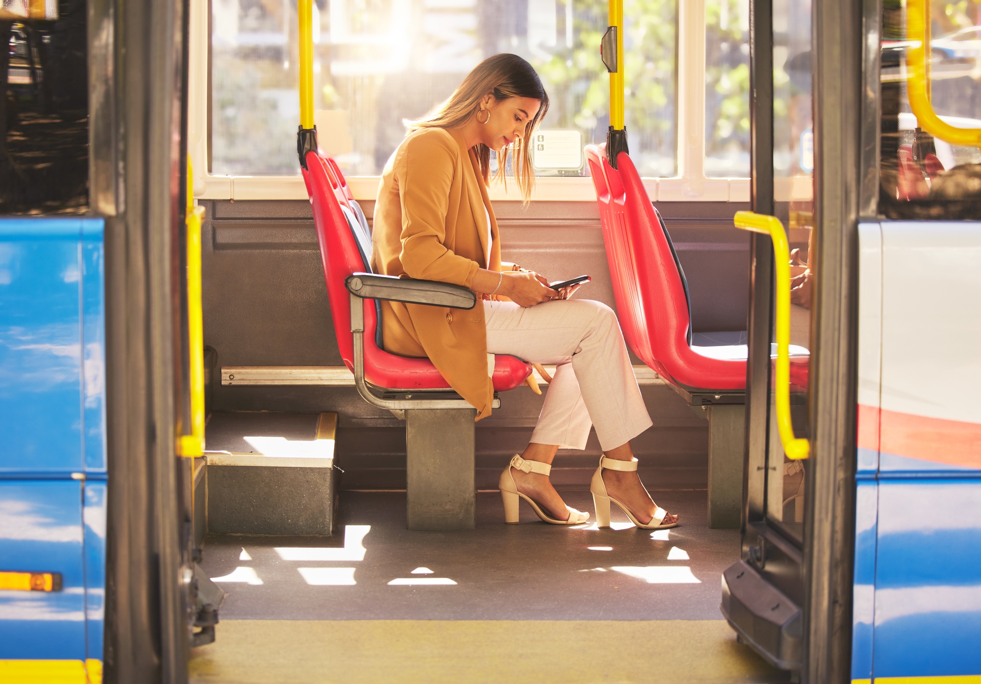 Woman in bus, sitting and typing on smartphone for social media, email and and travel on urban comm