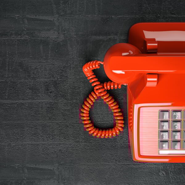 Red telephone on dirty background. Top view of vintage retro push button telephone