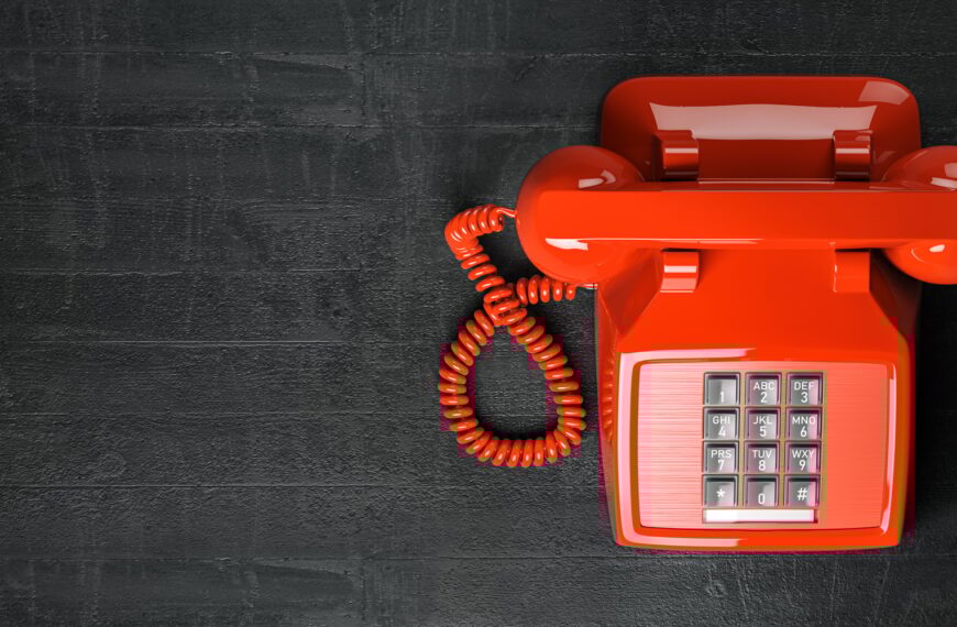 Red telephone on dirty background. Top view of vintage retro push button telephone